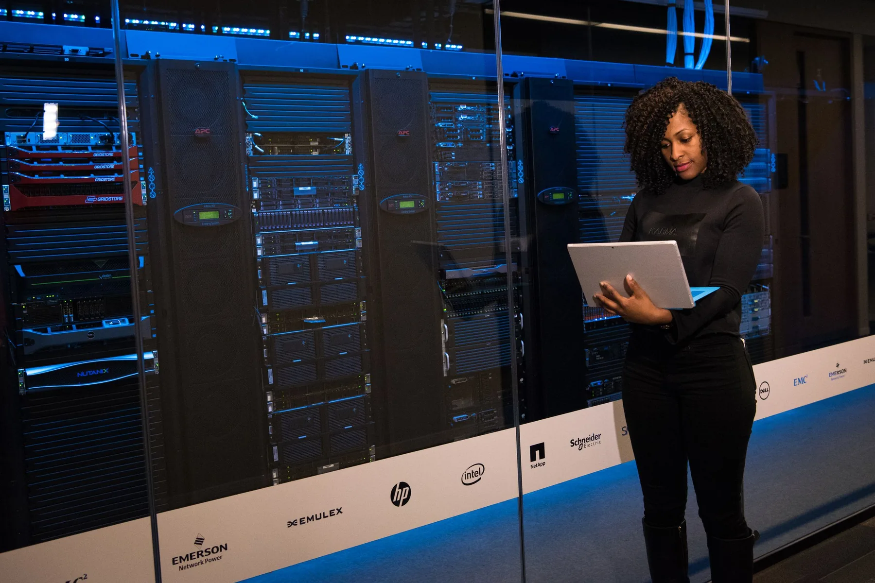 An engineer with a tablet checking server racks in a data centre